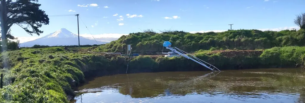 Electric vs. PTO Systems: Pros and Cons for Dairy Farm Effluent Management 12 Richard Meyer's new Nevada Electric Stirrer in a clay lined pond infront of Maunga Taranaki