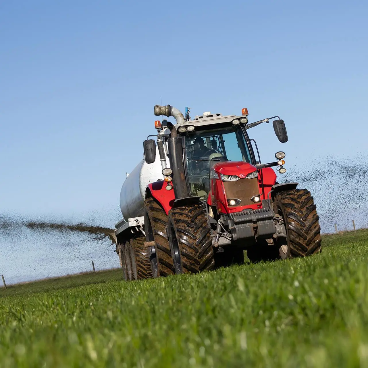 Red Ferdie Tractor pulling a Nevada Tridem Slurry Tanker, spreading dairy effluent
